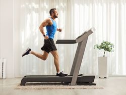 young-man-running-on-a-treadmill-at-home-royalty-free-image-1663128445.jpg